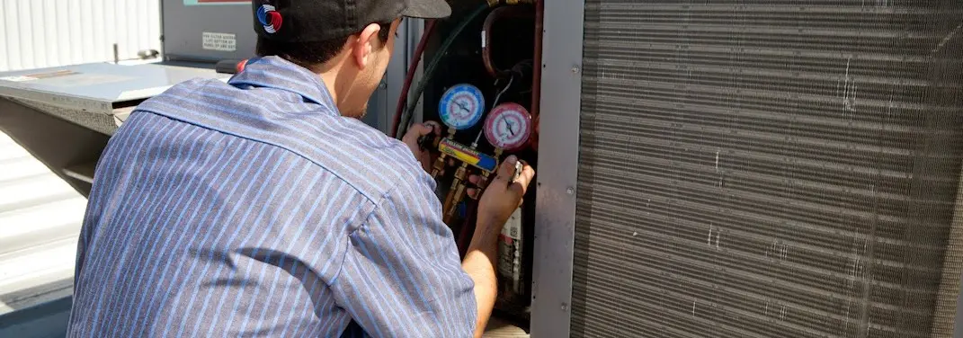 HVAC technician servicing a condenser unit in Killeen